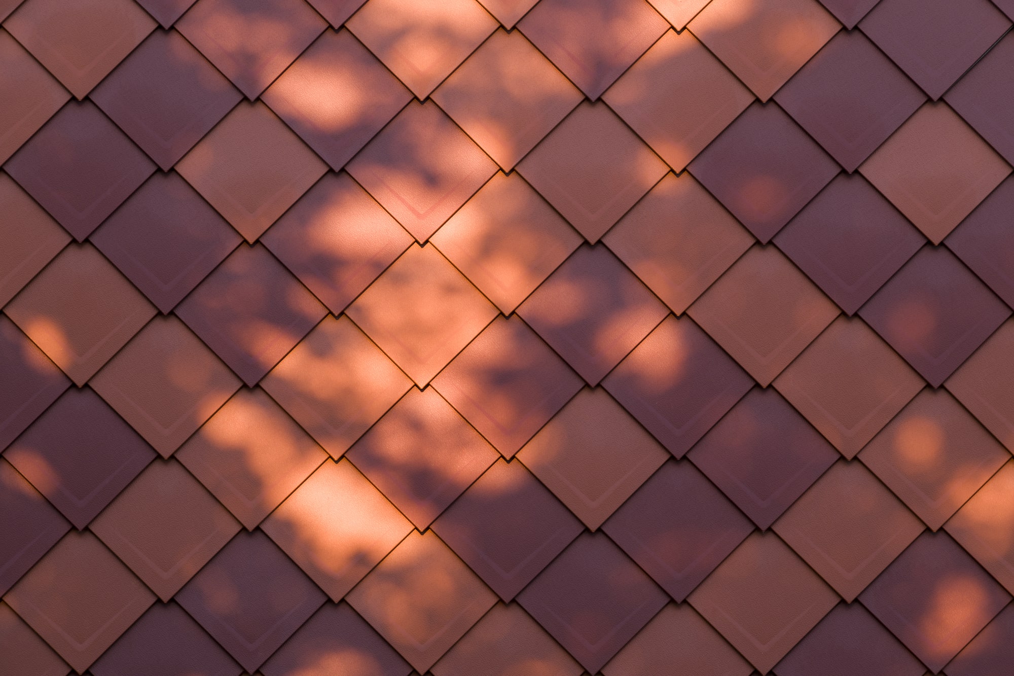 Toiture à motifs losangés éclairée par le soleil