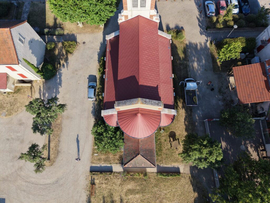 Vue aérienne d’un bâtiment à toiture rouge en aluminium