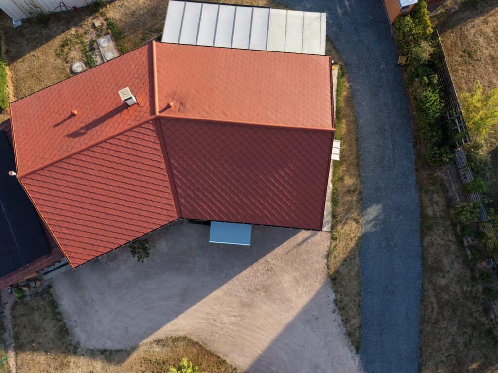 Vue aérienne d’une maison avec toiture rouge à plusieurs pans